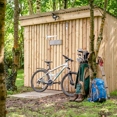 A mountain bike, golf club set, walking gear and rucksack outside a custom built secure shed at Great Ashley Farm in Wiltshire