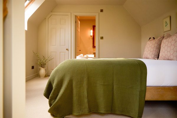 a view across the bed and towards the bathroom at Wisteria, a holiday cottage at Great Ashley Farm in Bradford-On-Avon